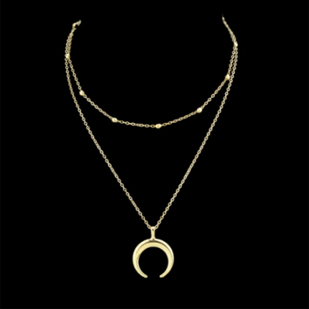 The gold horn multi layered Kelabu necklace on a black background