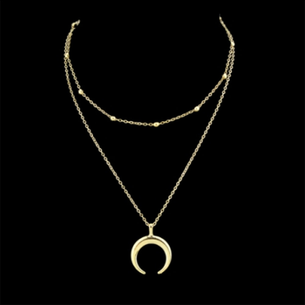 The gold horn multi layered Kelabu necklace on a black background 