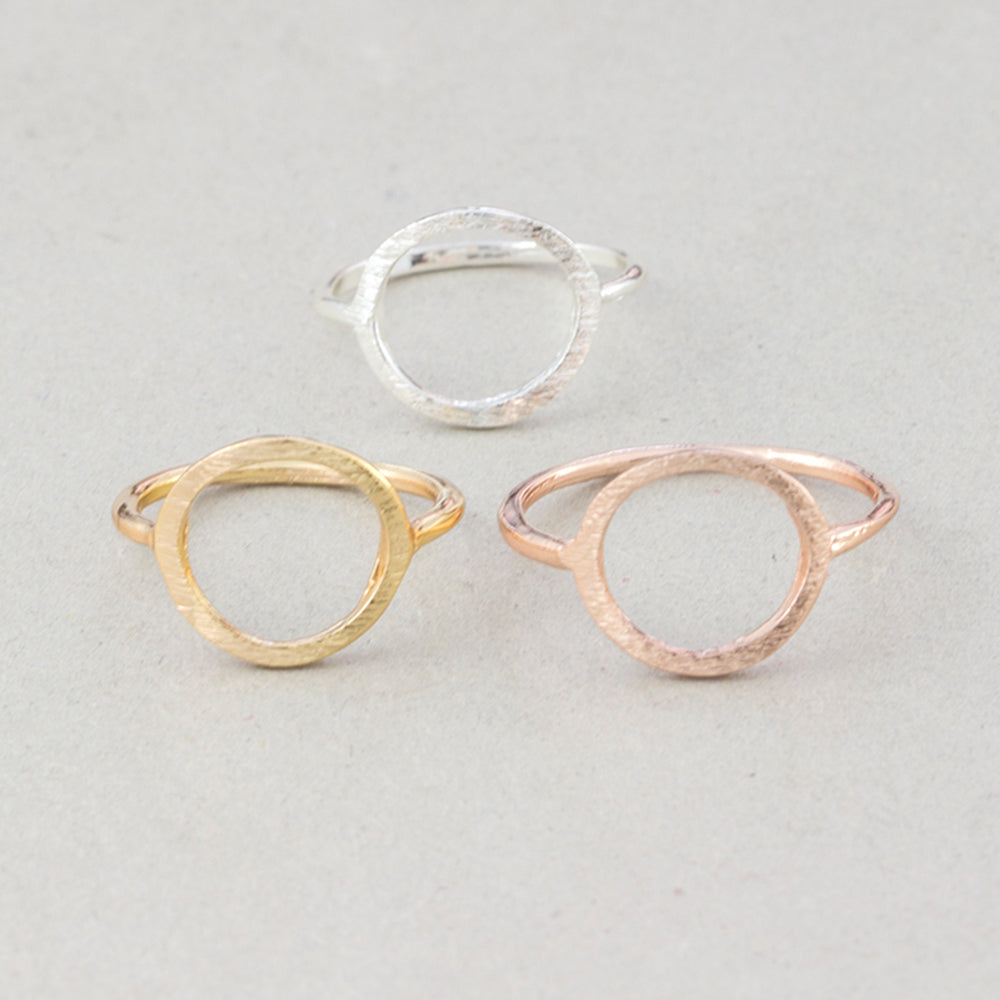 The Kelabu Karma Circle bohemian rings in all three different colours - gold, silver, and rose gold - on a light coloured background 