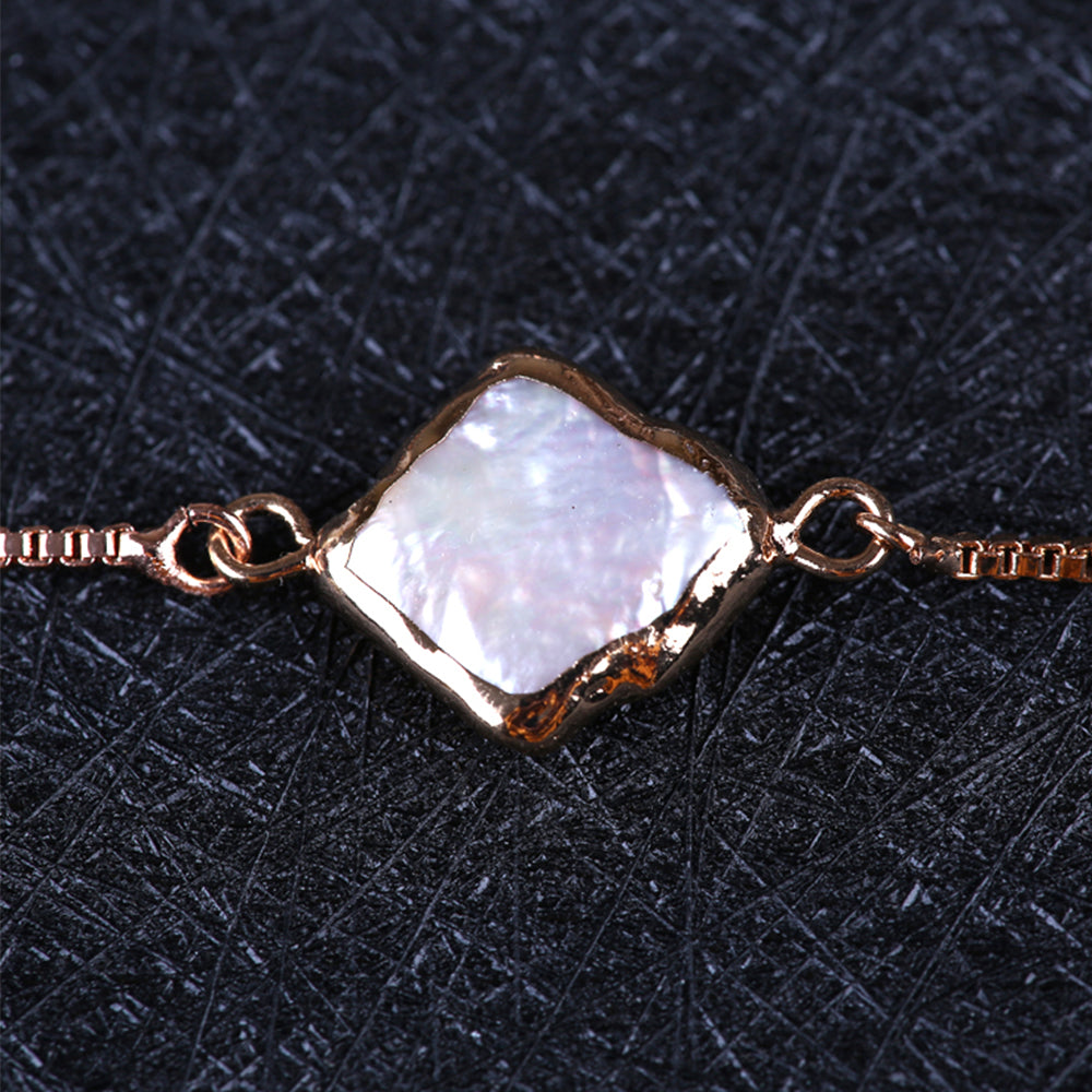 Stunning close up of the Kelabu tie bracelet and pearl effect pendant that sits in the middle of the bracelet