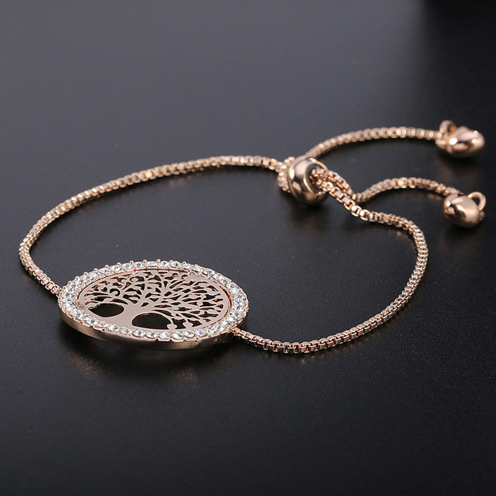 The gold tree bracelet from Kelabu on a plain black background where the gold colour of the bracelet stands out