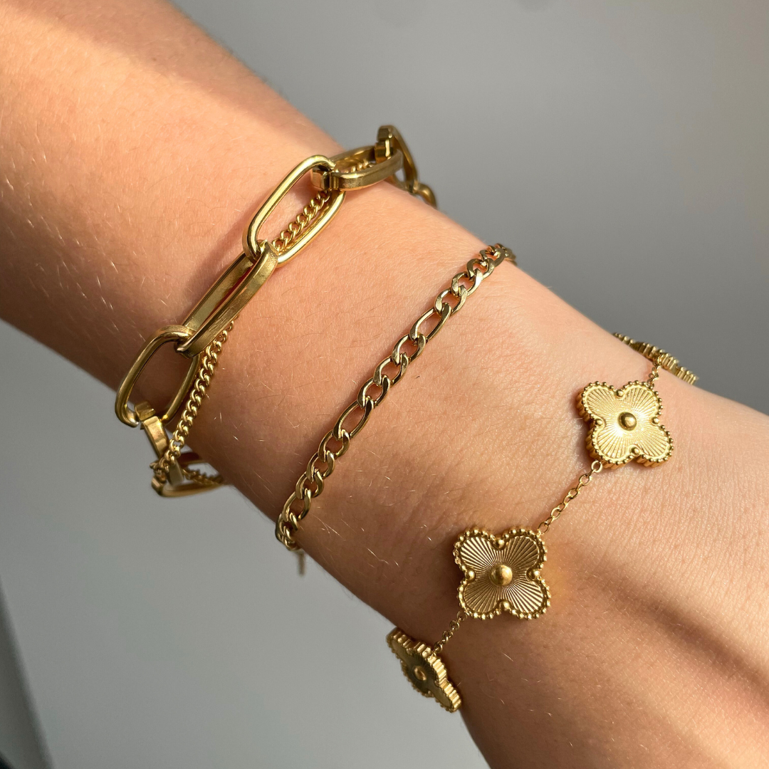dainty gold bracelet stack including gold clover flower charm bracelet