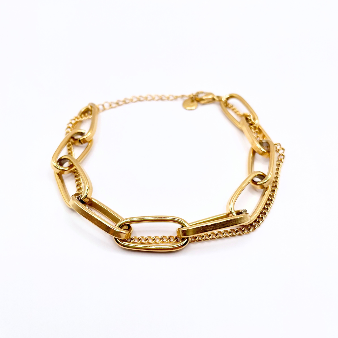 close up of dainty and chunky detailing on gold chain bracelet