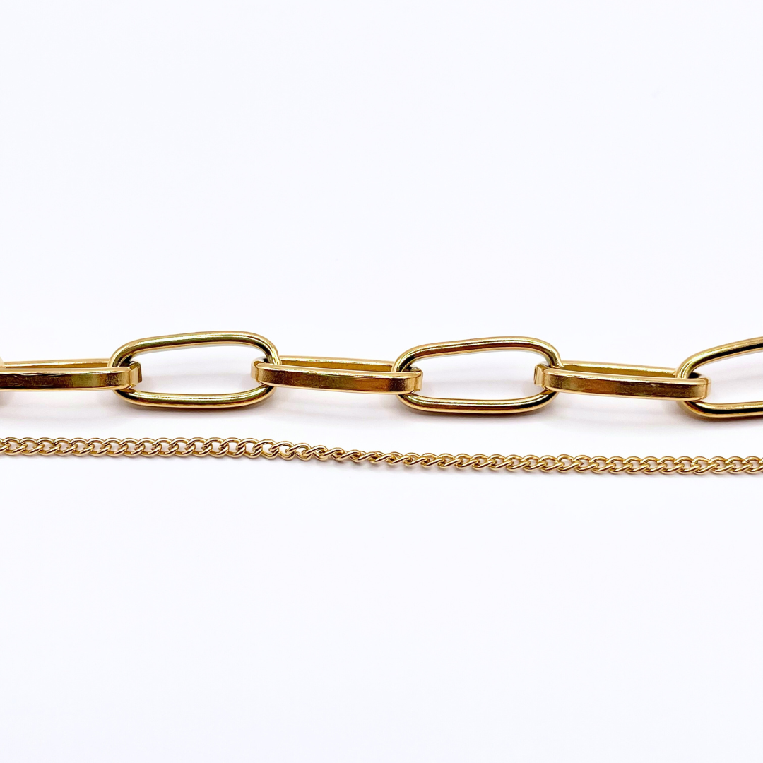 another close up shot of both the dainty gold chain and chunky chain on bracelet