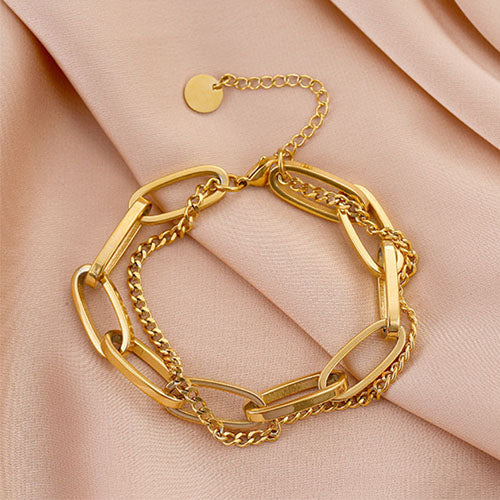 image of gold layered chain bracelet on pink shiny background