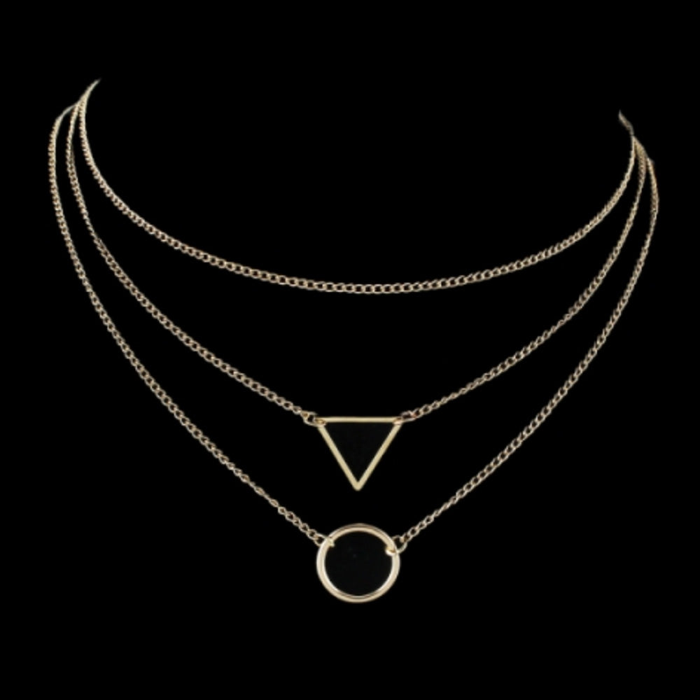 The Kelabu geometric statement necklace in Gold on a plain black background