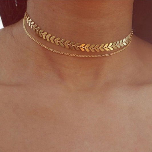A woman wearing the Kelabu gold choker necklace which features two different designs and is multi layered 