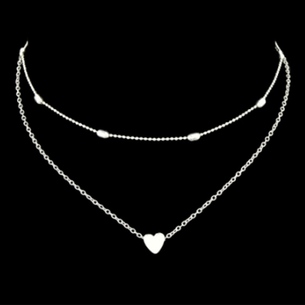 The beautiful Kelabu silver heart charm necklace and choker set pictured on a plain black background 