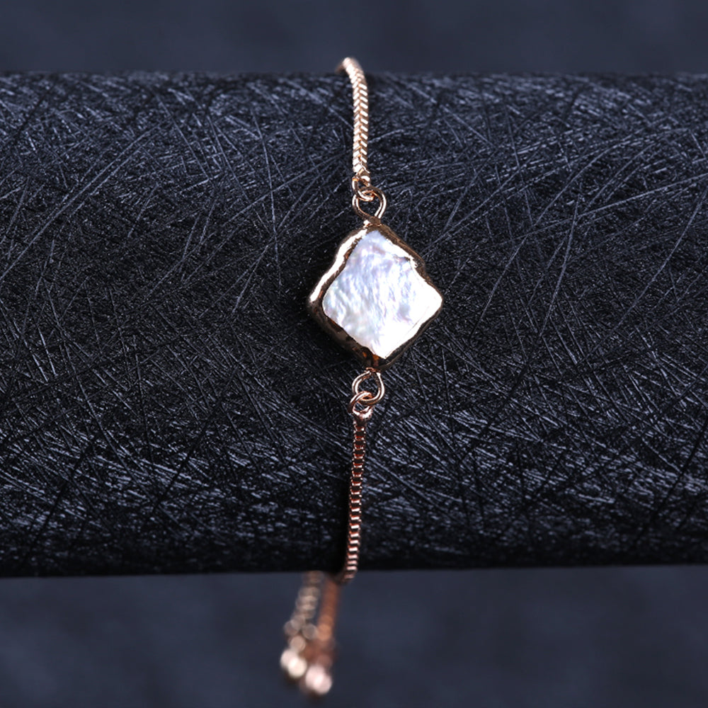 The rough pearl pave tie bracelet from Kelabu featuring a dazzling pearl effect charm set on a gold chain 
