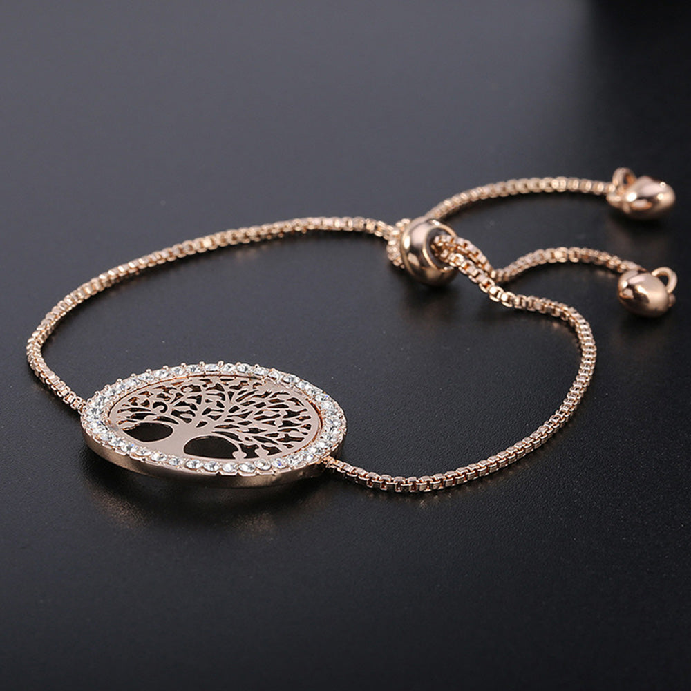 The gold tree bracelet from Kelabu on a plain black background where the gold colour of the bracelet stands out 